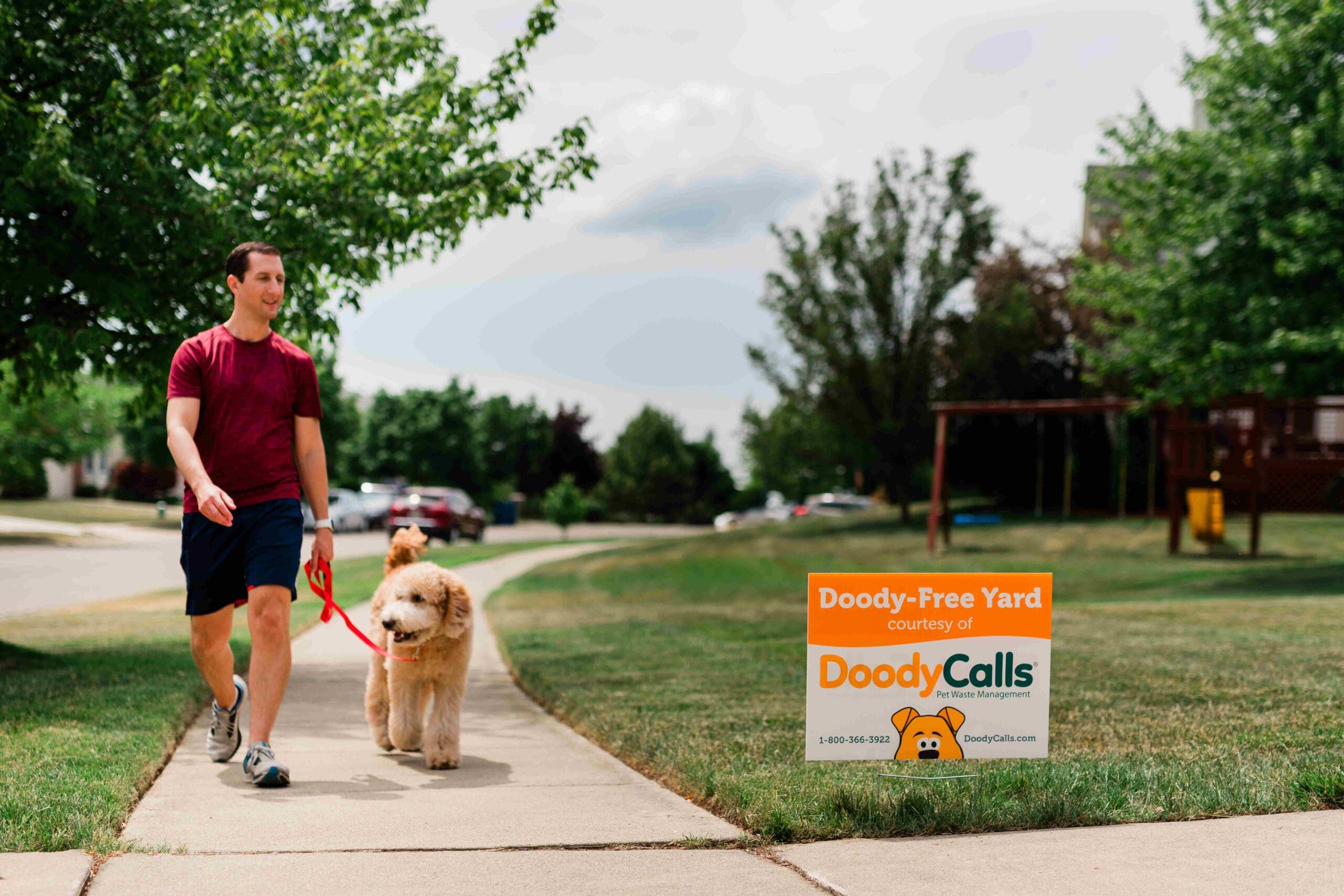 Pet owner walking with dog on sidewalk