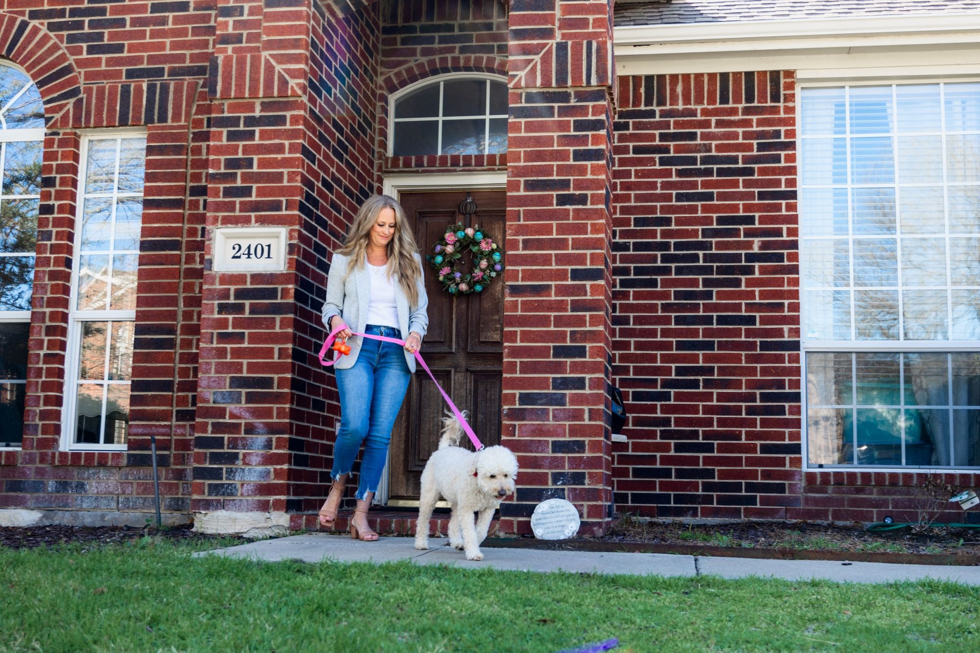 DoodyCalls franchise owner walking her dog outside of her house.